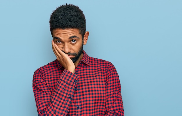 Jeune homme afro-américain portant des vêtements décontractés pensant regarder fatigué et ennuyé avec des problèmes de dépression avec les bras croisés