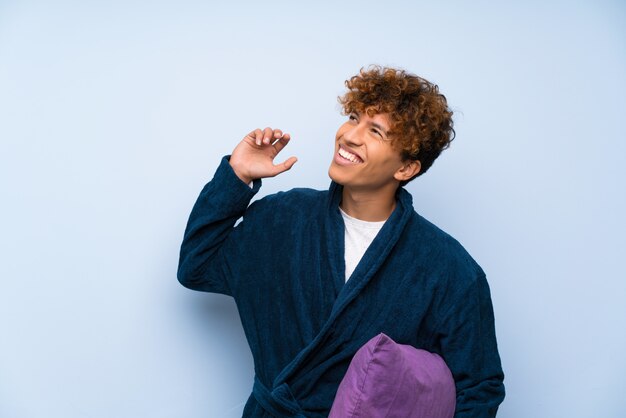 Jeune homme afro-américain en pyjama rire