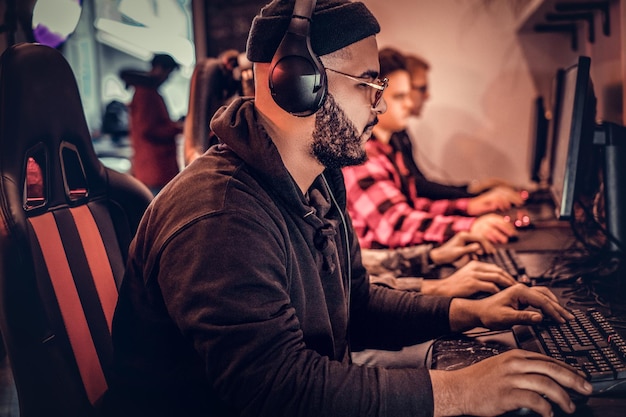 Un jeune homme afro-américain, qui aime passer du temps avec ses amis, jouer à un jeu vidéo multijoueur sur un PC dans un club de jeux ou un cybercafé.