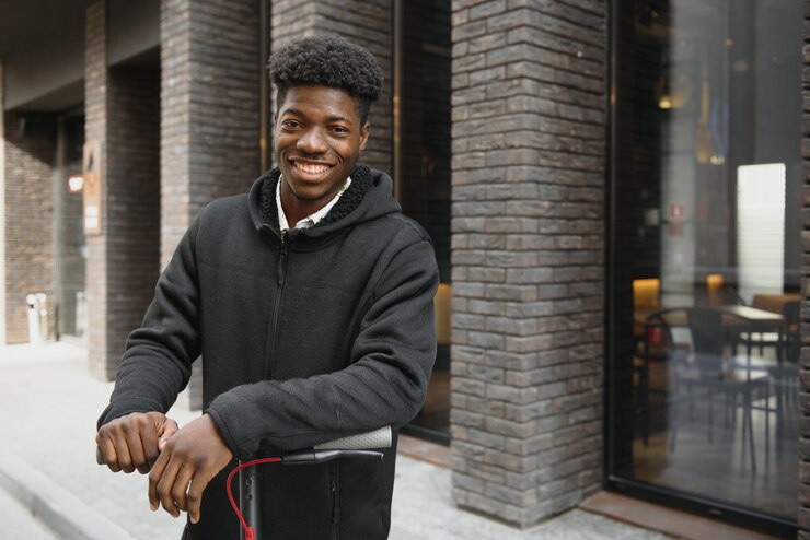 Photo jeune homme afro-américain avec scooter électrique dans la ville