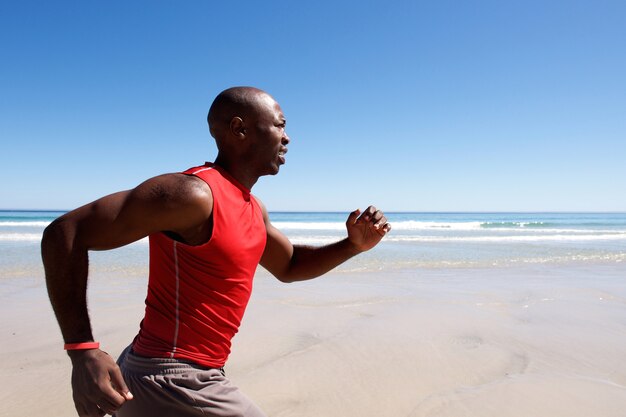 Jeune homme afro-américain sprint sur la plage