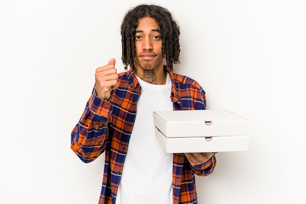 Jeune homme afro-américain tenant des pizzas isolé sur fond bleu montrant le poing à la caméra expression faciale agressive