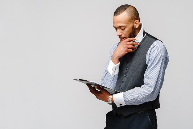 Un jeune homme afro-américain tenant une tablette et un stylo.