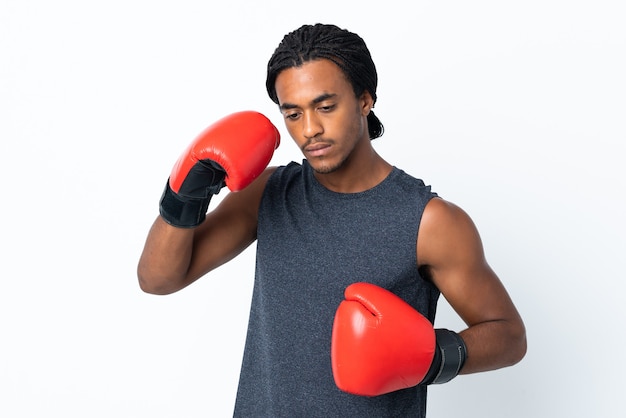 Jeune homme afro-américain avec des tresses isolé sur fond violet avec des gants de boxe