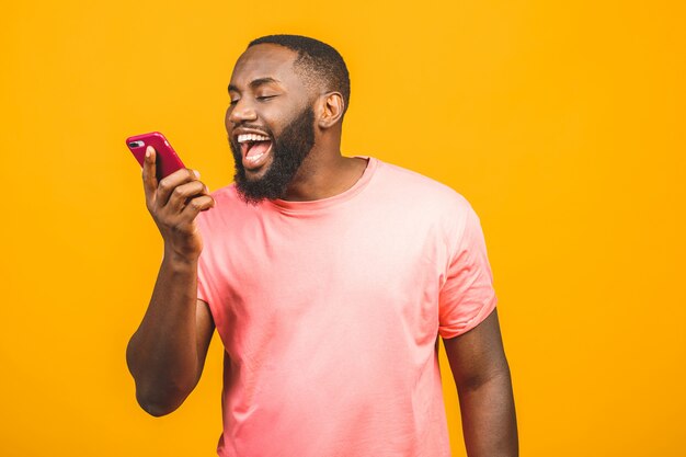 Jeune homme afro-américain utilisant un smartphone stressé, choqué de honte et de surprise, en colère et frustré. Peur et bouleversé par erreur.