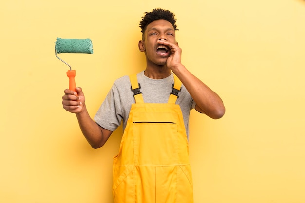 jeune homme afro contre le mur jaune