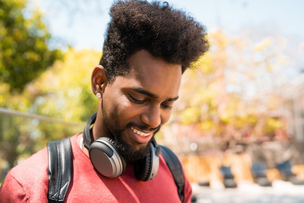 Jeune homme afro, écouter de la musique avec des écouteurs