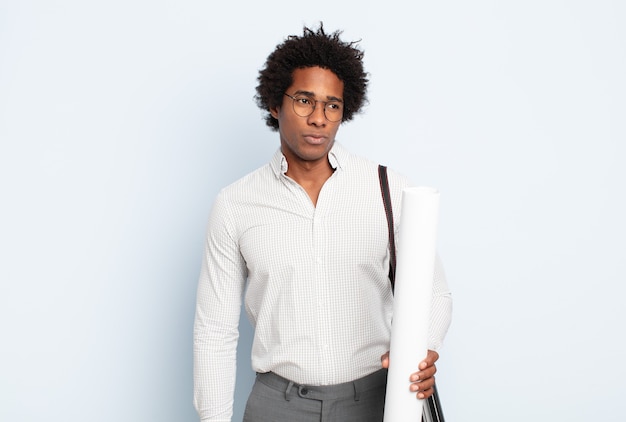 Jeune homme afro noir se sentant triste, bouleversé ou en colère et regardant sur le côté avec une attitude négative, fronçant les sourcils en désaccord