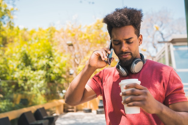 Jeune homme afro, parler au téléphone