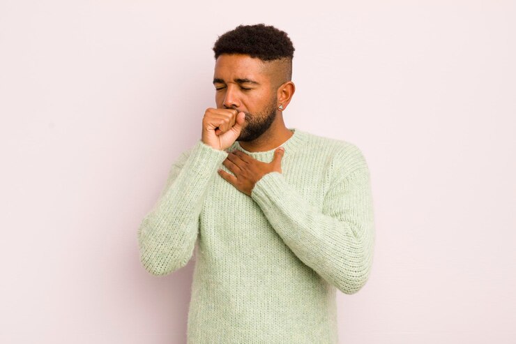 Photo jeune homme afro se sentant malade avec un mal de gorge et des symptômes de grippe toussant avec la bouche couverte
