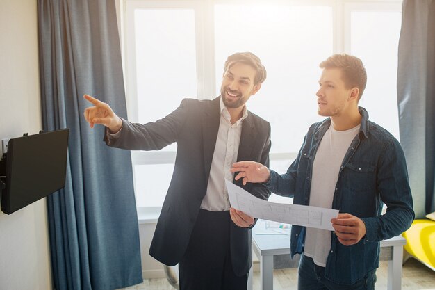 Jeune homme et agent immobilier avec plan