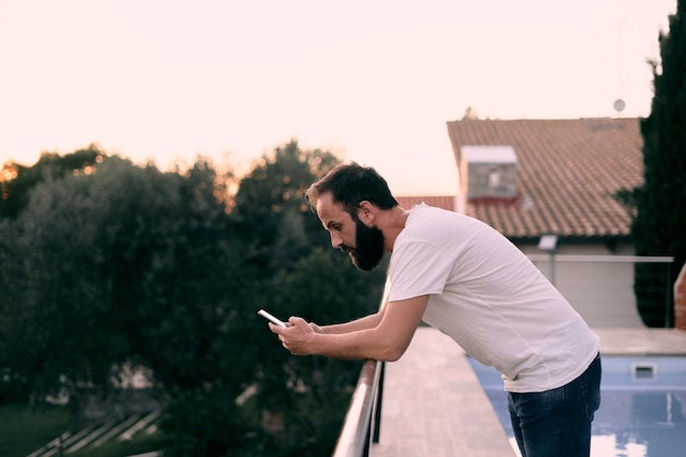 Jeune homme à l'aide d'une application de chat dans sa maison forestière