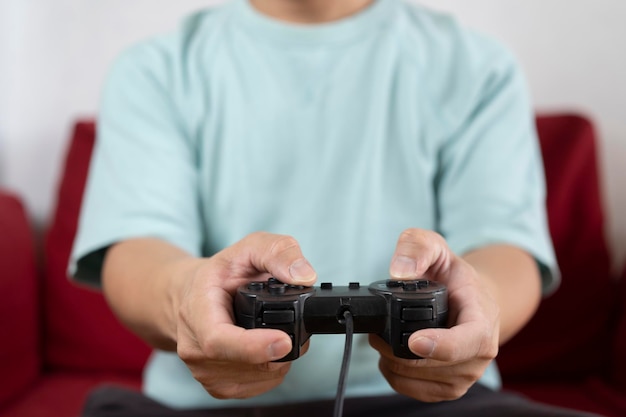 Jeune homme à l'aide d'un contrôleur de jeu vidéo jouant à des jeux vidéo