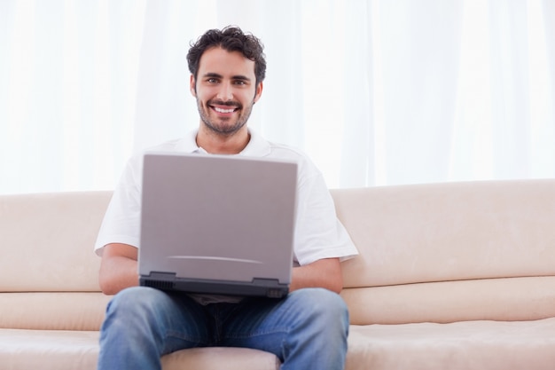 Jeune homme à l&#39;aide d&#39;un ordinateur portable