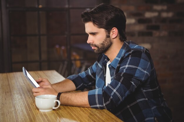 Jeune homme à l&#39;aide de sa tablette