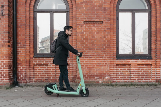 Photo jeune homme à l'aide d'un scooter électrique