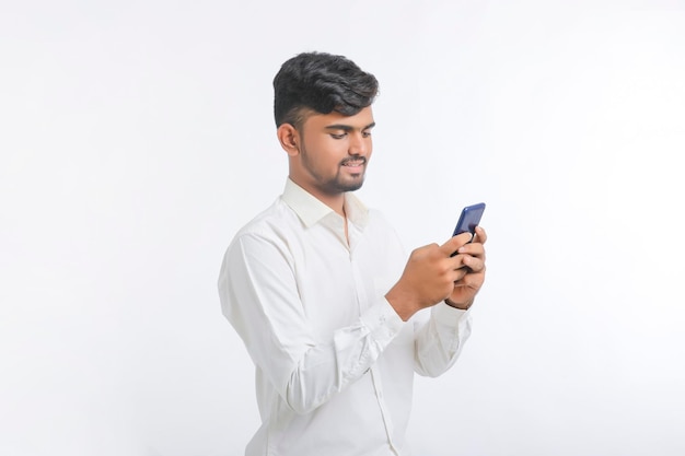 Jeune homme à l'aide de smartphone sur fond blanc.