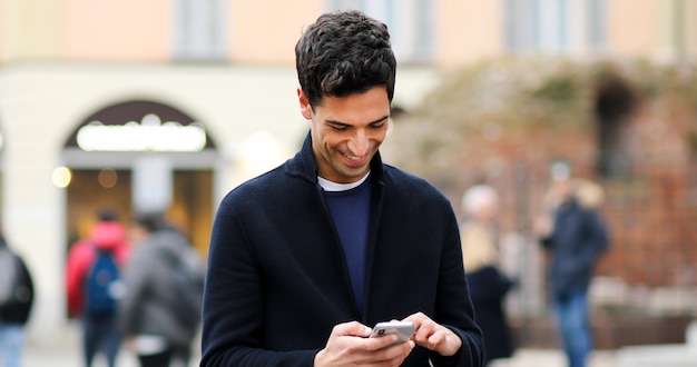 Jeune homme à l&#39;aide d&#39;un smartphone en plein air