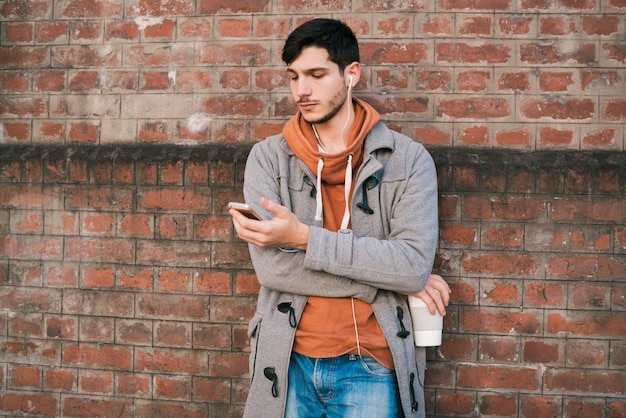 Jeune homme à l'aide de téléphone portable.