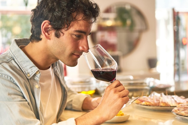 Le jeune homme aime la dégustation de vin au comptoir du bar