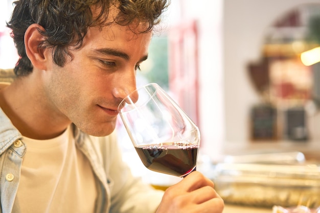 Le jeune homme aime la dégustation de vin au comptoir du bar