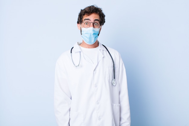 Jeune homme à l'air heureux et agréablement surpris, excité par une expression fascinée et choquée. concept de coronavirus