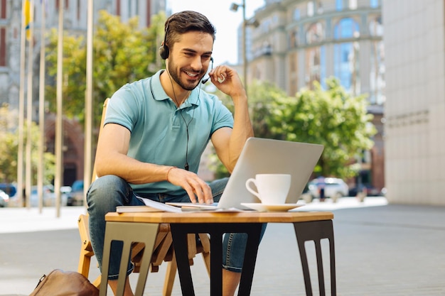 Jeune homme ambitieux travaillant sur une terrasse