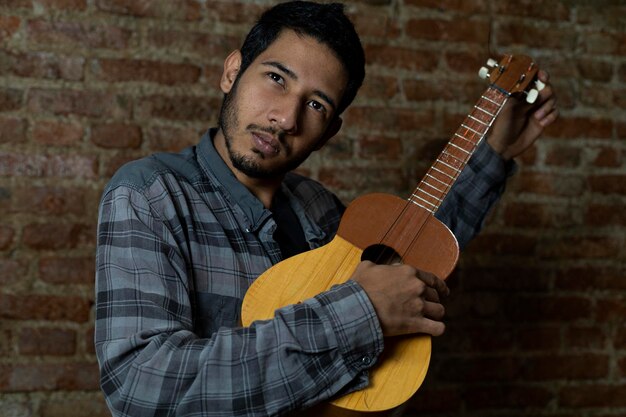 Jeune homme d'Amérique latine 24 tunes les cordes d'un quotCuatroquot un instrument de musique vénézuélien typique Music concept