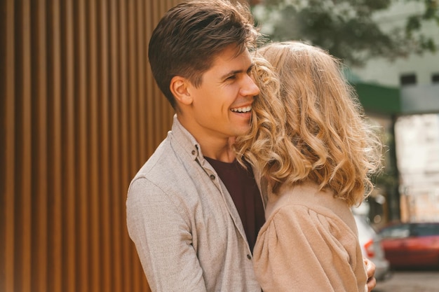 Jeune homme amoureux est heureux de voir et embrasse sa belle femme blonde