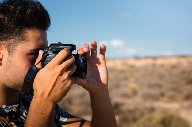 Jeune homme avec un appareil photo dans le désert des Bardenas Reales, Navarre, Pays Basque.