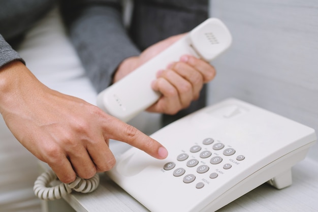 Jeune homme appelant au téléphone en position couchée sur la chambre