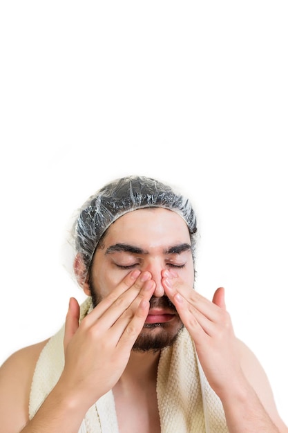 Jeune homme appliquant un masque cosmétique sur le visage dans un salon de spa