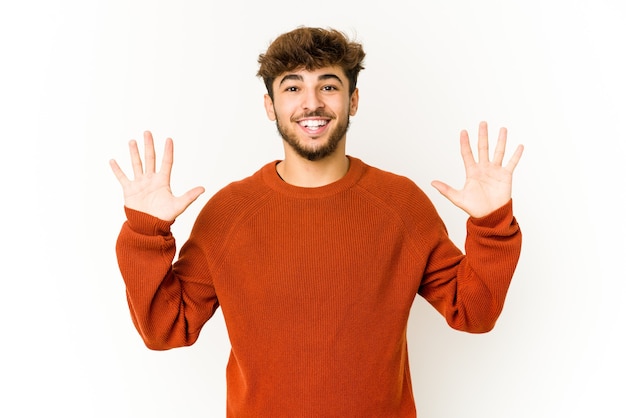 Jeune homme arabe sur blanc montrant le numéro dix avec les mains.