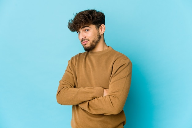 Jeune homme arabe sur bleu malheureux à huis clos avec une expression sarcastique.