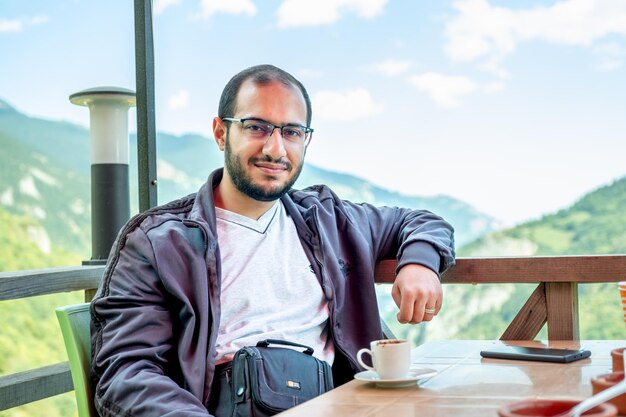 Photo un jeune homme arabe buvant du café pendant ses vacances dans la nature