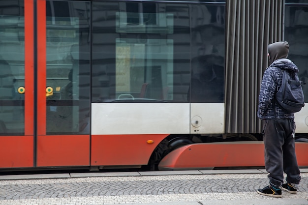 Jeune homme à l'arrêt de tramway à Prague à côté de la maison dansante