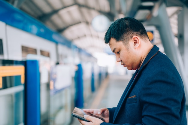 Jeune homme asiatique d'affaires à l'aide de sa tablette numérique dans le métro, train, métro