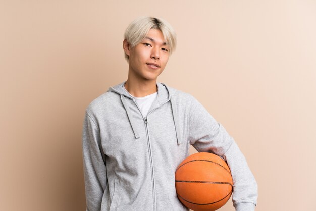 Jeune homme asiatique avec ballon de basket