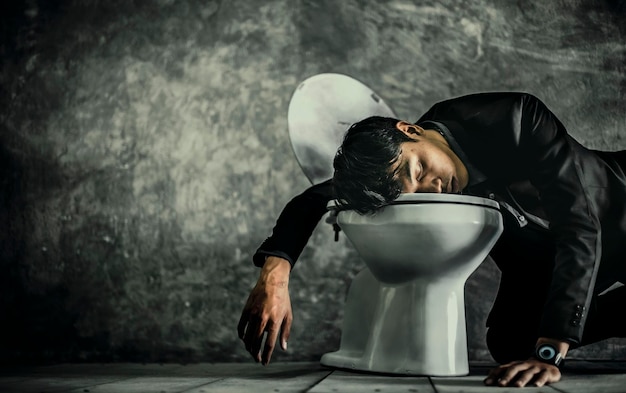 Un jeune homme asiatique dormant sur une toilette parce qu'il boit trop provoque une déception dans le travail