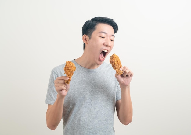 Jeune homme asiatique avec du poulet frit à portée de main