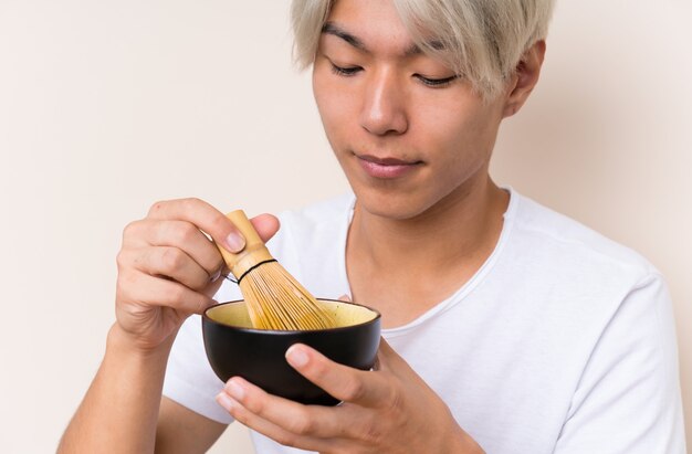 Jeune homme asiatique avec du thé matcha dans une table