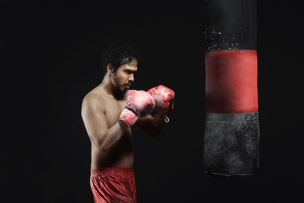 Jeune homme asiatique entraînement de boxe avec sac de boxe