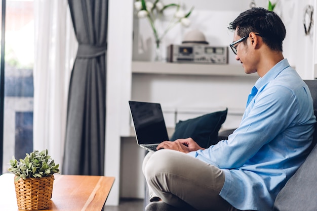 Jeune homme asiatique heureux souriant créatif se détendre à l'aide d'un ordinateur de bureau travaillant et réunion de vidéoconférence en ligne chat à la maison