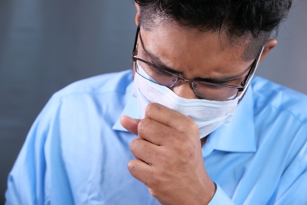 Un jeune homme asiatique avec un masque protecteur au visage se sentant triste