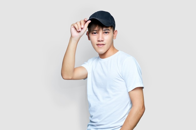 Jeune homme asiatique portant une chemise blanche et un chapeau noir.