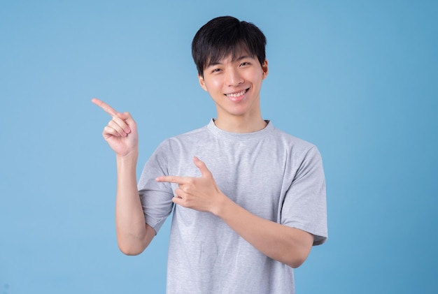 Jeune homme asiatique posant sur fond bleu