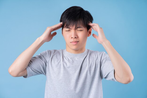 Jeune homme asiatique posant sur fond bleu