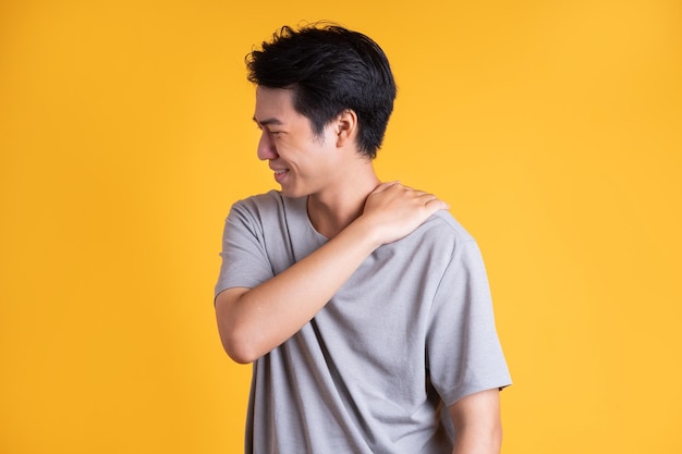 Jeune homme asiatique posant sur un fond jaune