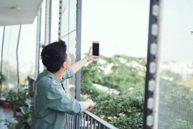 Jeune homme asiatique prenant selfie