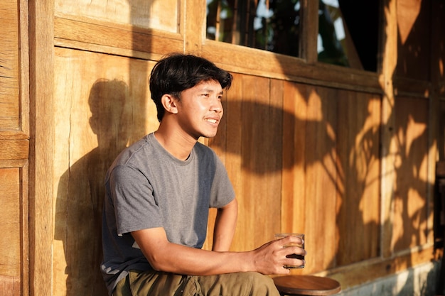 Photo jeune homme asiatique profitant d'un café seul